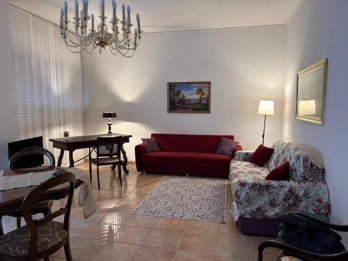ein Wohnzimmer mit einem roten Sofa und einem Tisch in der Unterkunft Apulia appartament in Taranto