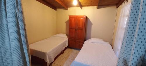 Habitación pequeña con 2 camas y armario en YVAGA en Puerto Iguazú