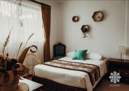 a bedroom with a bed with a green pillow on it at Inti Kamari Wellness Lodge & Convention Center in Santa Isabel