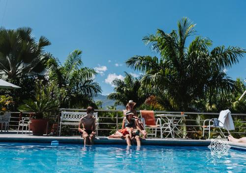 un grupo de personas sentadas en el borde de una piscina en Inti Kamari Wellness Lodge & Convention Center, en Santa Isabel