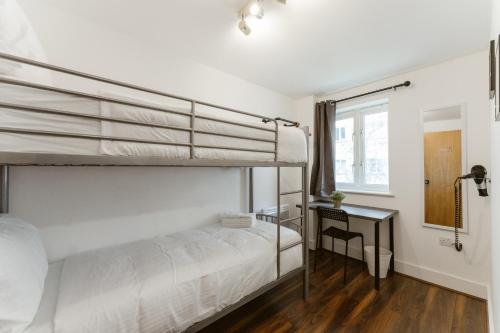 a bedroom with two bunk beds and a desk at LimeHouse Double Rooms - 3 in London