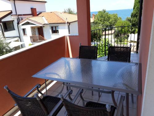 szklany stół na balkonie z krzesłami w obiekcie Meduza&Manta w mieście Izola