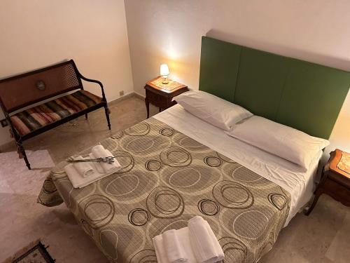 Schlafzimmer mit einem großen Bett mit einem grünen Kopfteil in der Unterkunft Apulia appartament in Taranto