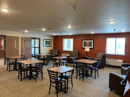 una sala de espera con mesas y sillas en un edificio en Midtown Suites - Greenville, en Greenville