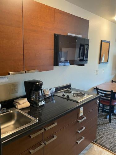 a kitchen with a sink and a stove top oven at Midtown Suites - Greenville in Greenville