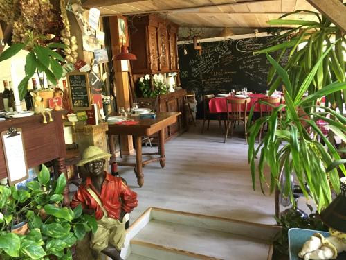 posąg człowieka w restauracji z roślinami w obiekcie Bed and B Les Truffières w mieście Trémolat
