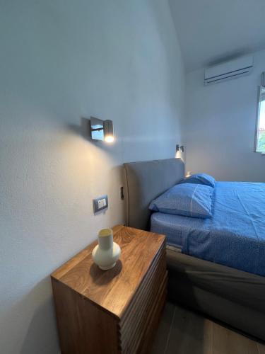 a bedroom with a bed and a table with a vase on it at Villa Paladino in Ioppolo