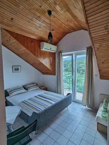 a bedroom with a large bed with a wooden ceiling at Apartments Vejo in Korčula