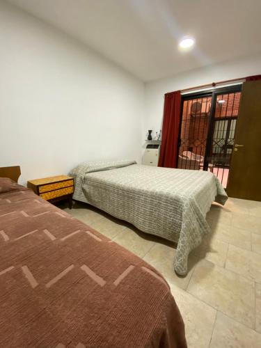 1 dormitorio con 2 camas y ventana en Excelente y amplio dpto 3 dormitorios c cochera privada en Mendoza