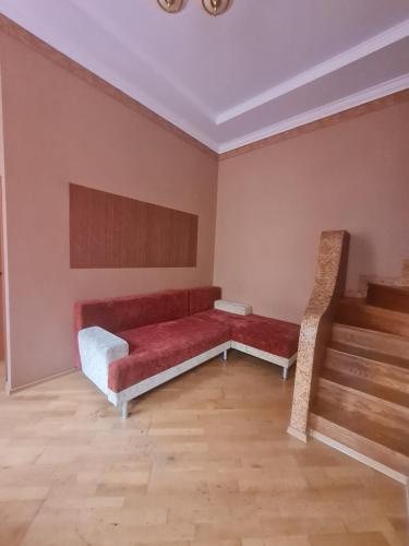 une chambre avec un canapé rouge et un escalier dans l'établissement Центр, Євгена Коновальця, 3, à Loutsk