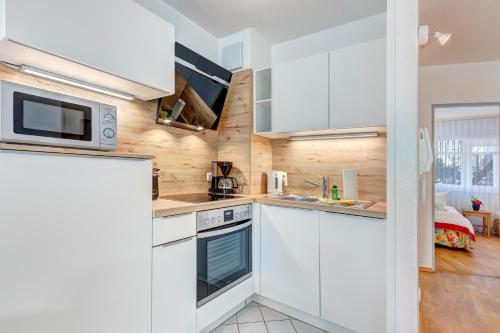 a kitchen with white cabinets and a microwave at Strandnähe! Moderne 3 Zimmer Ferienwohnung!! in Bansin