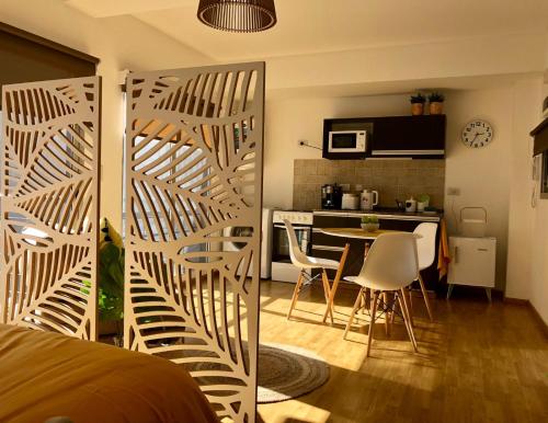 Una habitación con una cama y una cocina con una mesa. en Hermoso estudio amoblado con cochera MOVISTAR ARENA, en Buenos Aires