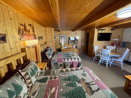 a room with two beds and a living room at Sportsman Lodge Melrose MT in Melrose