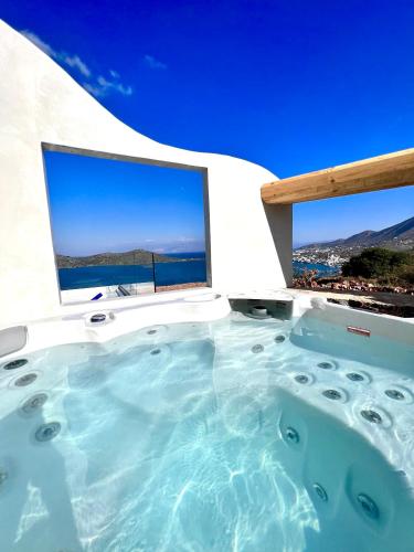 a hot tub with a view of the ocean at New Serenity Art Villa Elounda in Elounda
