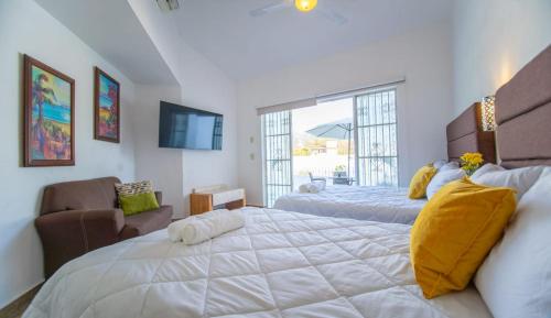 - une chambre avec un grand lit blanc et une fenêtre dans l'établissement Casa Melanie, Alberca y Asador Privados, à Puerto Vallarta