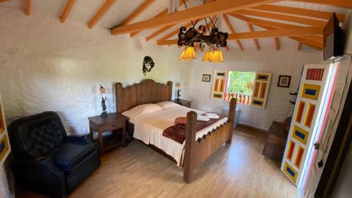 1 dormitorio con 1 cama y 1 silla en La Kolorina hotel campestre, en Jericó