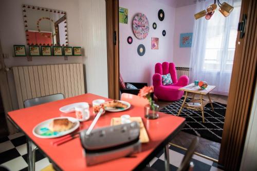 Cette chambre comprend une table rouge avec des assiettes de nourriture. dans l'établissement The Vintage Bed and Broc', à Saint-Calais