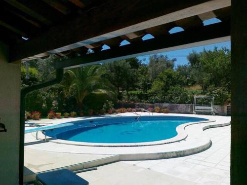 una gran piscina en un patio con sombrilla en A Casa da Celeste, en Fagilde