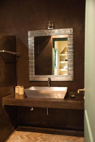 a bathroom with a sink and a mirror at Jnane Allia in Douar Soukkane
