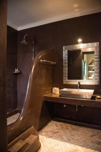 a bathroom with a tub and a sink and a mirror at Jnane Allia in Douar Soukkane