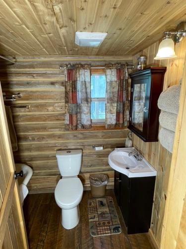 a small bathroom with a toilet and a sink at Sportsman Lodge Melrose MT in Melrose