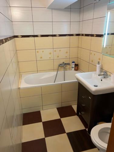 a bathroom with a tub and a sink and a toilet at Apartament Kwaskowa Góra in Kazimierz Dolny