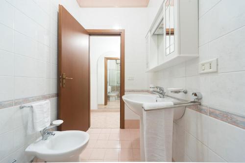 Baño blanco con lavabo y aseo en Nina Home - Selfcheck-in, en Canicattini Bagni