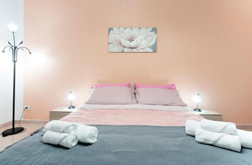 1 dormitorio con 1 cama grande y toallas. en Nina Home - Selfcheck-in, en Canicattini Bagni