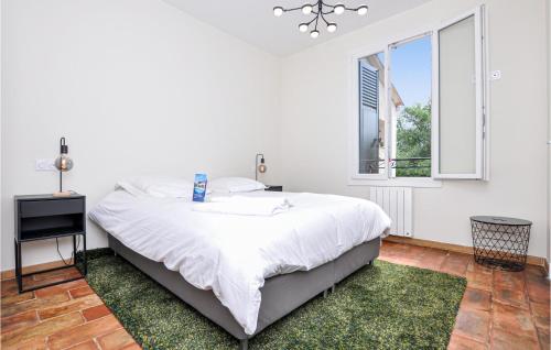 a white bedroom with a large bed and a window at Awesome Apartment In Saint-jeannet With Kitchen in Saint-Jeannet