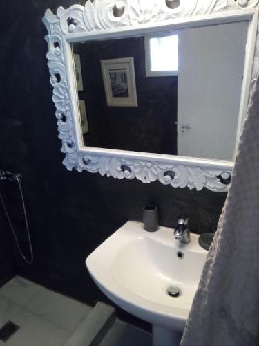a bathroom with a sink and a mirror at Small Vila in Panayía Mesosporítissa