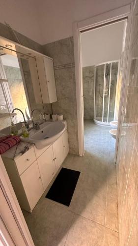 a bathroom with a sink and a mirror and a shower at Edens house con parcheggio privato in Rapallo