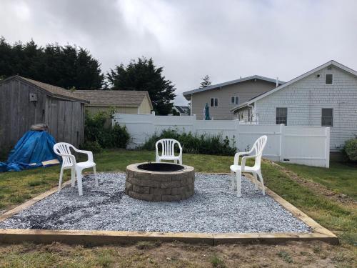 two chairs sitting around a fire pit in a yard at 12 Feake Avenue Sandwich - Cape Cod in Sandwich