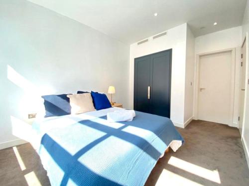 倫敦的住宿－London Excel City Side Apartment，一间位于客房内的卧室,配有蓝色和白色的床