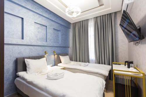 Cette chambre comprend 2 lits et une télévision. dans l'établissement Amelia Hotel, à Almaty