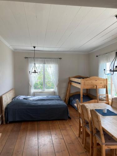 Schlafzimmer mit einem Bett, einem Tisch und einem Schreibtisch in der Unterkunft Proselinsgården in Bjursås