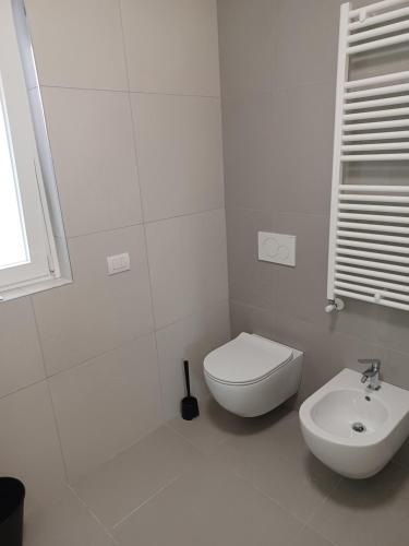 een witte badkamer met een toilet en een wastafel bij TRAVERSA I APARTMENT in Bari