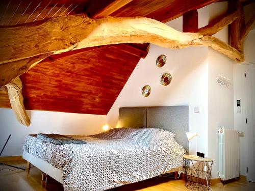 een slaapkamer met een bed en een groot houten plafond bij Gite Domaine Des Pierres Blanches in Belmontet