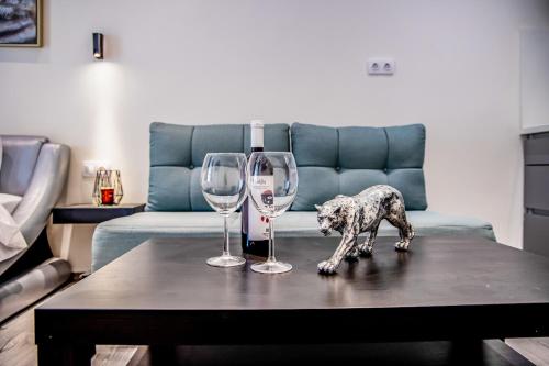 a dog statue on a table with two wine glasses at Diamond Suites 32 in Thessaloniki