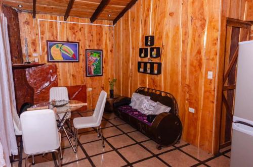 a living room with a couch and a table and chairs at Cabañas Lunas del Poás 