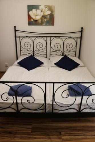 a black and white bed with blue pillows on it at Penzion 4 Dvory in České Budějovice