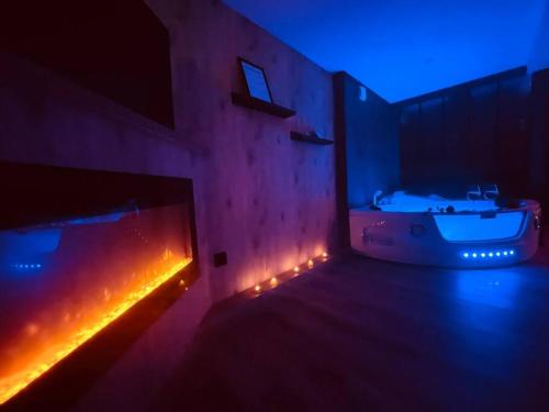 une pièce sombre avec une baignoire et une baignoire dans l'établissement L'Atelier des Rêves - appartement balnéo Rouen, à Rouen