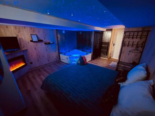 - une chambre avec un lit et une lumière bleue dans l'établissement L'Atelier des Rêves - appartement balnéo Rouen, à Rouen