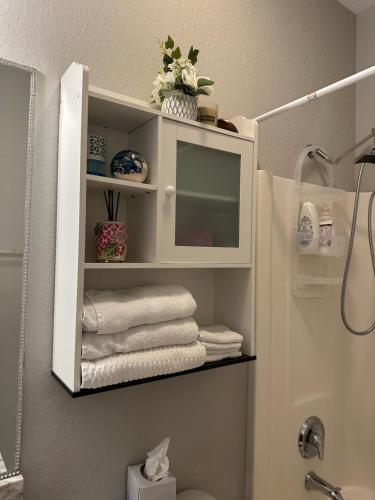 uma casa de banho com um armário branco com toalhas em Quite room in a family home em Lehigh Acres