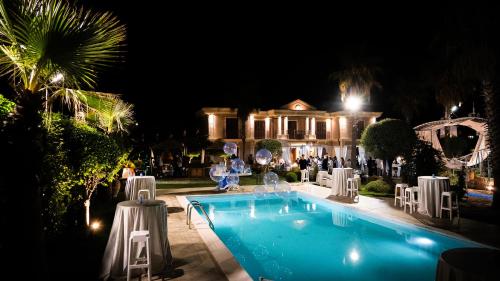 a swimming pool in front of a house at night at Villa Caleo in Gioia Tauro