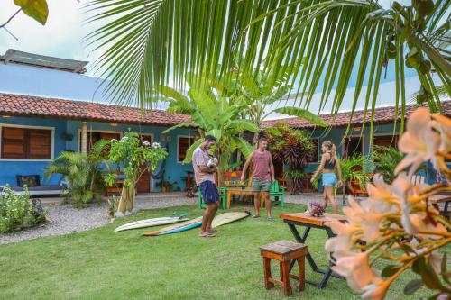 a group of people standing in a yard with surfboards at Back to the Beach Hostel - Pipa in Pipa