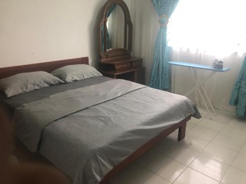 a bedroom with a bed and a table and a mirror at AGMA Homestay in Kuantan