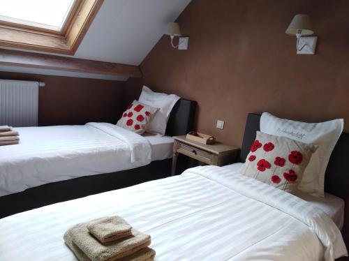 ein Schlafzimmer mit 2 Betten und Handtüchern darauf in der Unterkunft 't Hooghe Licht Bed & Breakfast in Zonnebeke