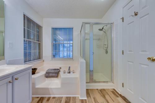 a white bathroom with a shower and a sink at Charlotte Vacation Rental Near Motor Speedway! in Charlotte