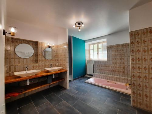 un bagno con due lavandini e una vasca rosa di Maison de caractère / Petit Versailles Normand a Valognes