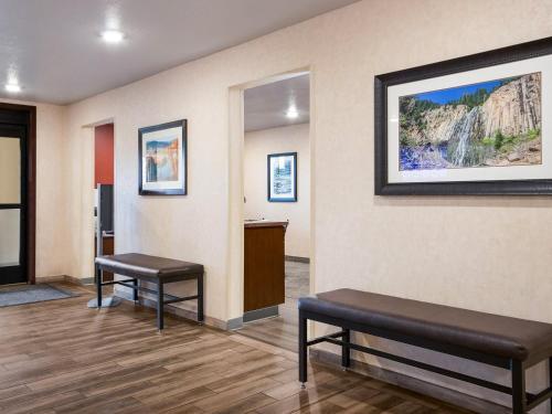 a waiting room with two benches and a refrigerator at Midtown Suites - Greenville in Greenville